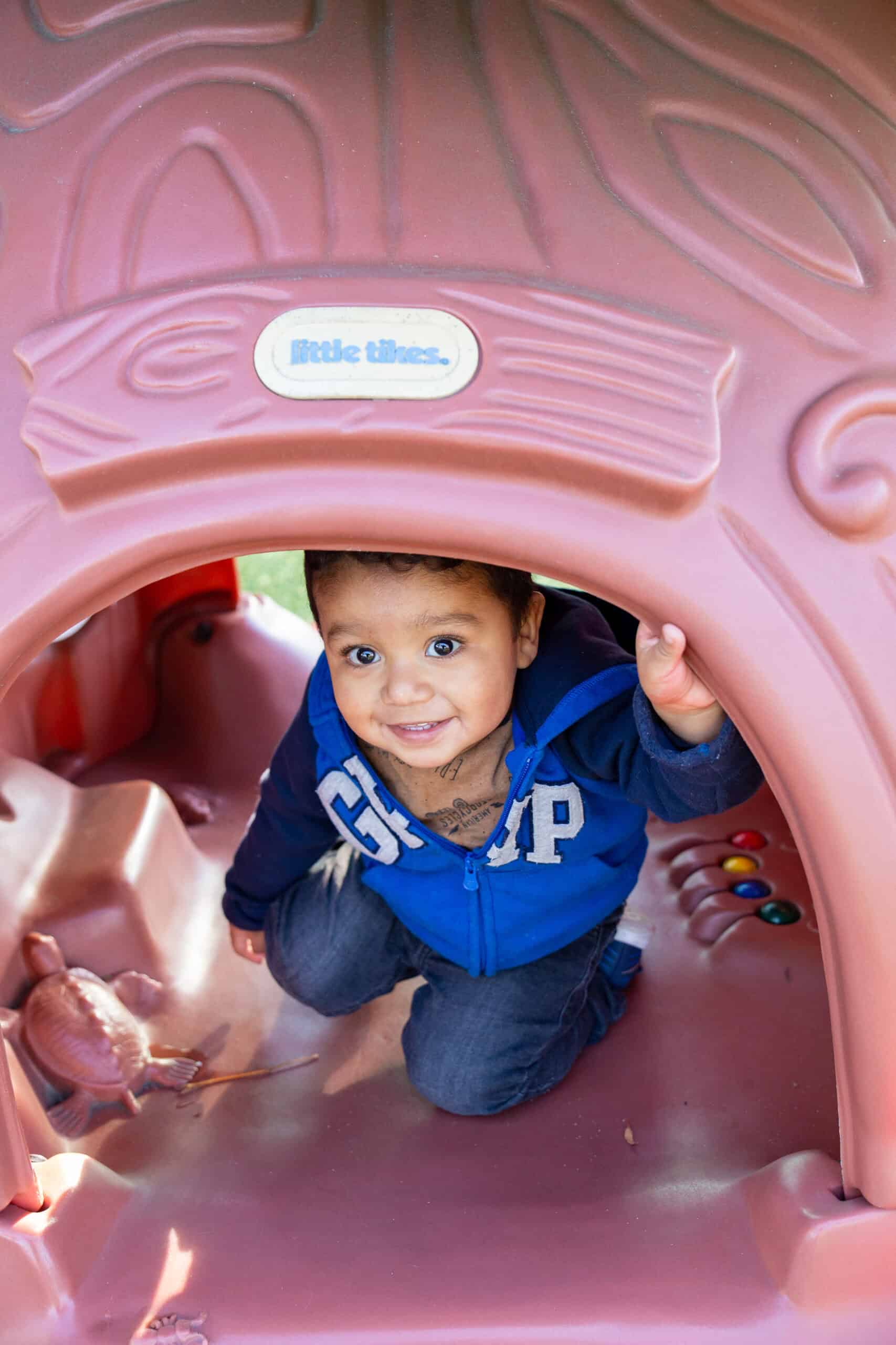 Child on playground smiling at camera
