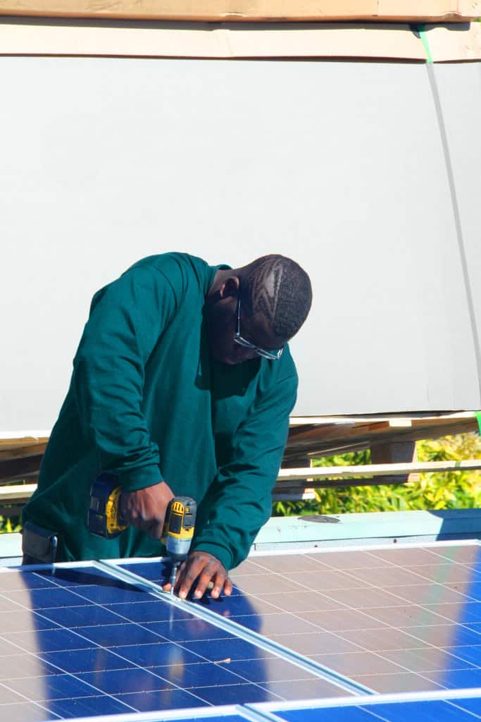 MAAC Workforce Development - a man using power tools on solar panel outside
